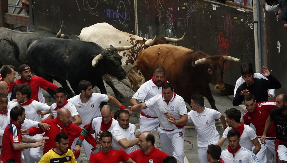 Mozos corriendo en la calle Estafeta con los Miura
