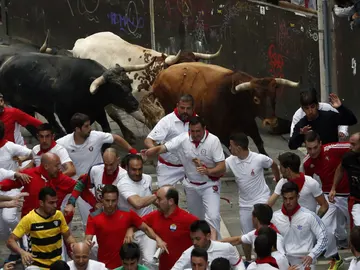 Mozos corriendo en la calle Estafeta con los Miura Mozos corriendo en la calle Estafeta con los Miura