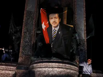 Un manifestante ondea una bandera con la foto del presidente turco Tayyip Erdogan durante una manifestación pro Gobierno en la plaza Taksim en Istanbul. Un manifestante ondea una bandera con la foto del presidente turco Tayyip Erdogan durante una manifestación pro Gobierno en la plaza Taksim en Istanbul.
