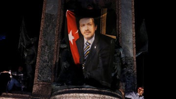 Un manifestante ondea una bandera con la foto del presidente turco Tayyip Erdogan durante una manifestación pro Gobierno en la plaza Taksim en Istanbul.