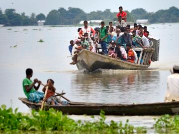 Un grupo de personas abandona su pueblo en barco tras ser afectado por las inundaciones 