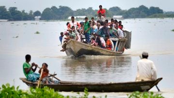 Un grupo de personas abandona su pueblo en barco tras ser afectado por las inundaciones 