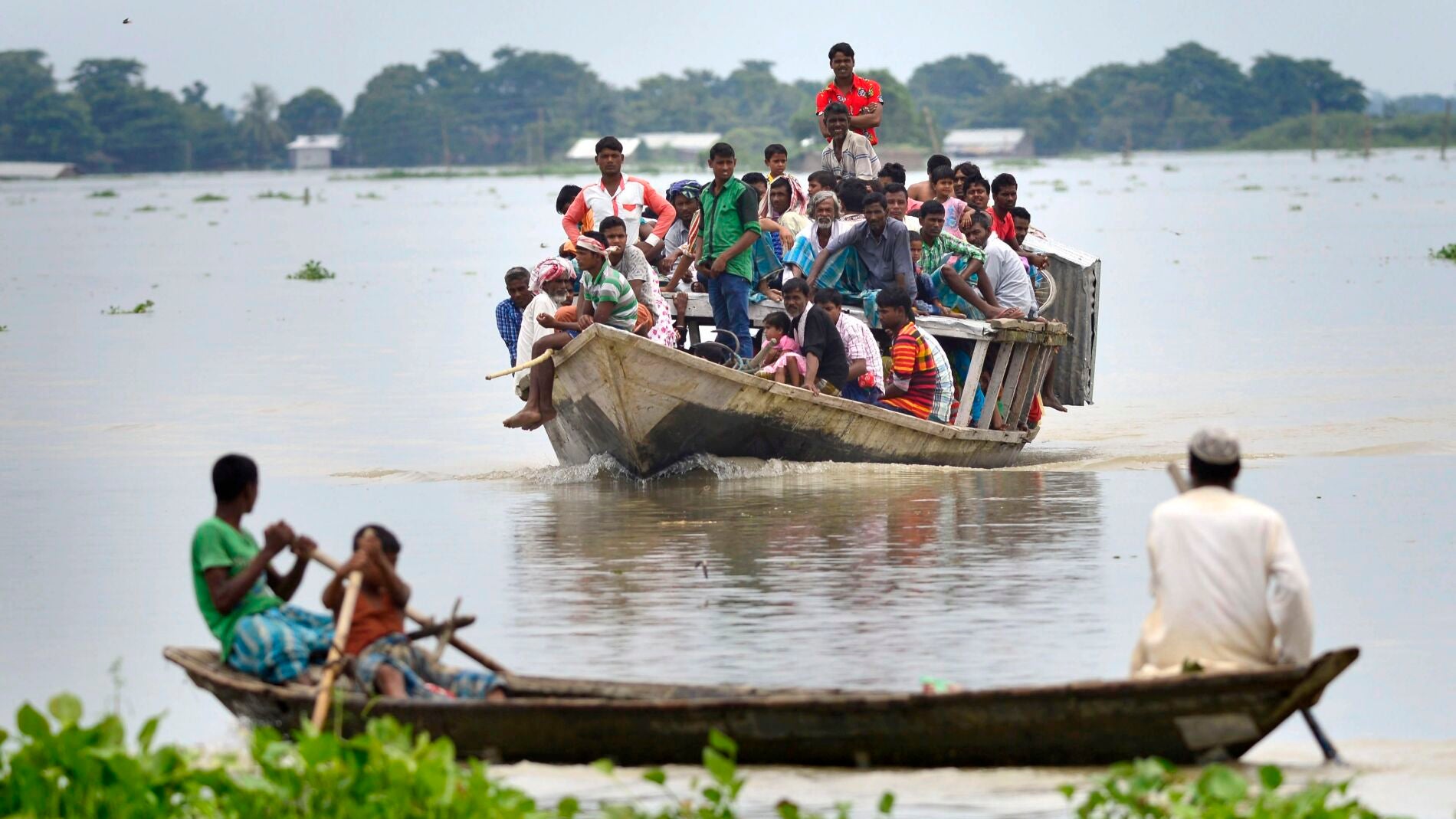 Un grupo de personas abandona su pueblo en barco tras ser afectado por las inundaciones 