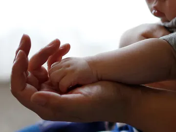 La mano de un bebé sobre la de un adulto La mano de un bebé sobre la de un adulto