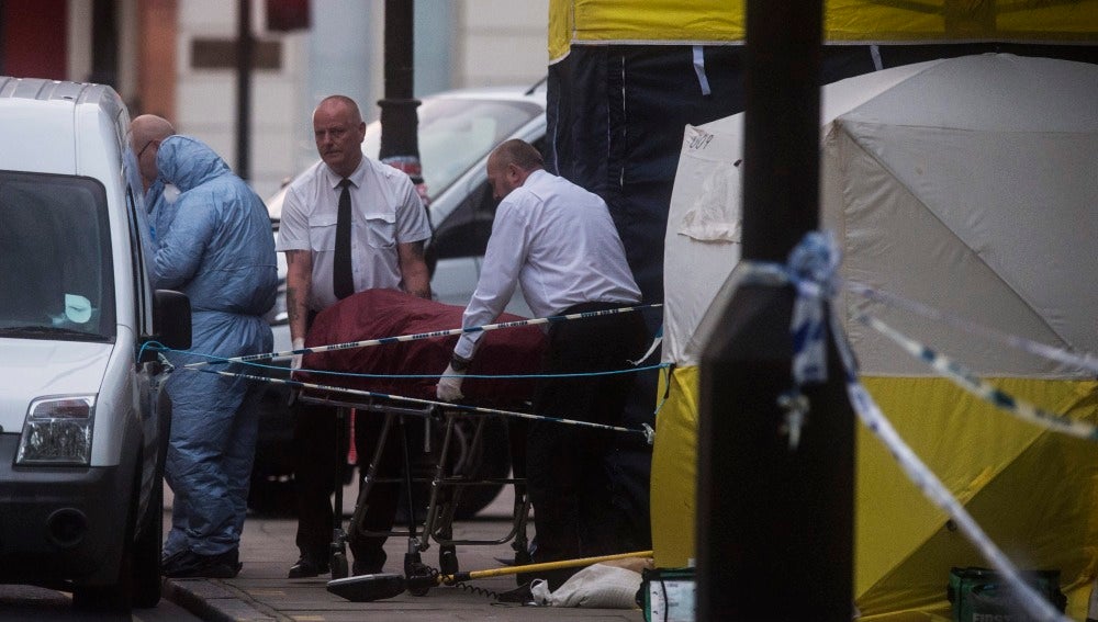 Investigadores retiran un cuerpo en la escena donde una mujer murió en Londres