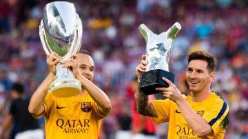 Iniesta y Messi posando con trofeos del Barça