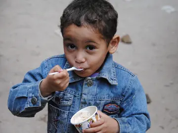 Un niño desfavorecido disfruta de su helado solidario Un niño desfavorecido disfruta de su helado solidario