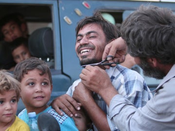 Un sirio corta su barba tras la liberación de Manbij