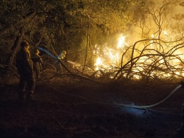 En la imagen, brigadistas trabajando para sofocar las llamas del incendio forestal declarado a última hora de la tarde de ayer en Cualedro