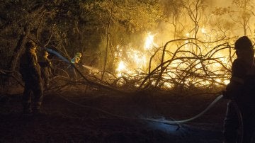 En la imagen, brigadistas trabajando para sofocar las llamas del incendio forestal declarado a última hora de la tarde de ayer en Cualedro