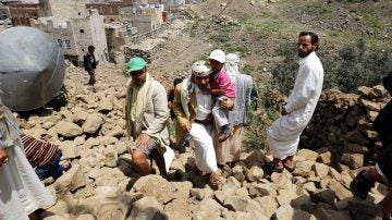 Yemeníes inspeccionan una casa destruida por aviones en Saná, Yemen