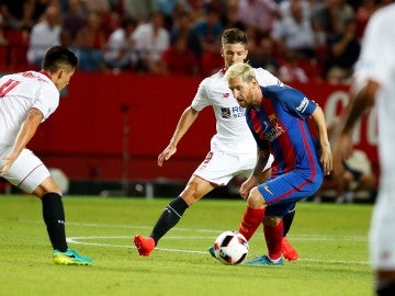 Messi conduce el balón ante la defensa del Sevilla