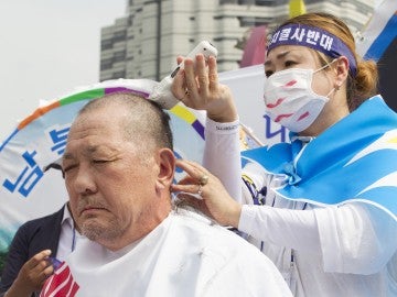 Ciudadano de Corea del Sur rapándose la cabeza en señal de protesta.