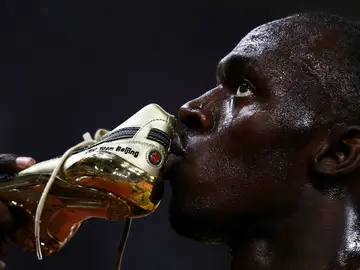 Usain Bolt besa una de sus zapatillas tras la carrera de los 100 metros de los Juegos de Pekín Usain Bolt besa una de sus zapatillas tras la carrera de los 100 metros de los Juegos de Pekín