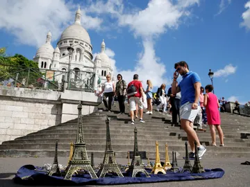 Un turista camina delante de la iglesia de Sacre Coeur de Montmartre en París durante el mes de agosto. Un turista camina delante de la iglesia de Sacre Coeur de Montmartre en París durante el mes de agosto.