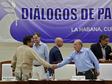 Humberto de la Calle y las FARC principal negociador de Colombia Iván Márquez se dan la mano después de firmar el protocolo.