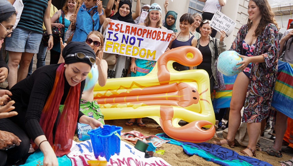 Los manifestantes de diferentes sociedades realizar una manifestación denominada ' Wear What You Want ' con temas como un estilo de fiesta en la playa , frente a la embajada francesa en Londres