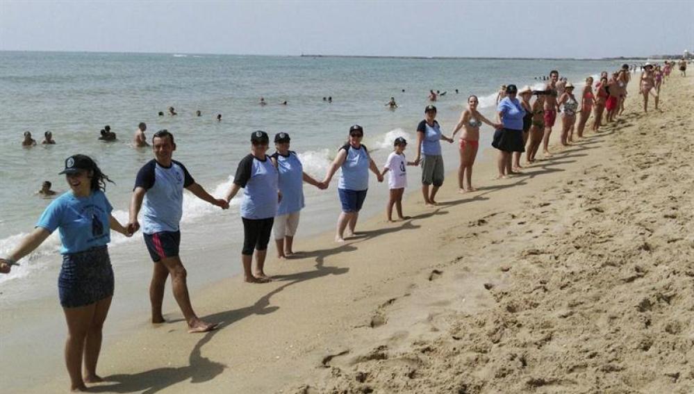 Cadena humana de más de cinco kilómetros en protesta a la violencia machista, en Isla Cristina