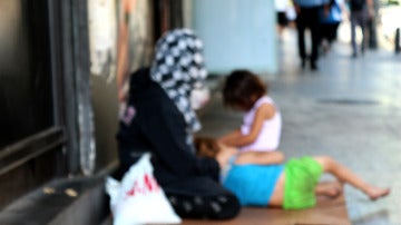 Una mujer pide junto a dos niños en la calle de Hamra, en el centro de Beirut