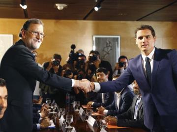  El jefe del Gobierno, Mariano Rajoy y el líder de Ciudadanos, Albert Rivera, se estrechan la mano durante la reunión de sus respectivas delegaciones en la que van a certificar el acuerdo de investidura