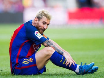 Messi, sentado en el césped durante un partido con el Barça