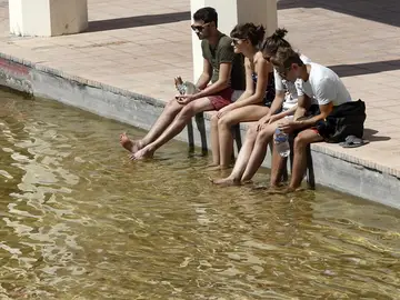 Un grupo de jóvenes se refresca los pies Un grupo de jóvenes se refresca los pies
