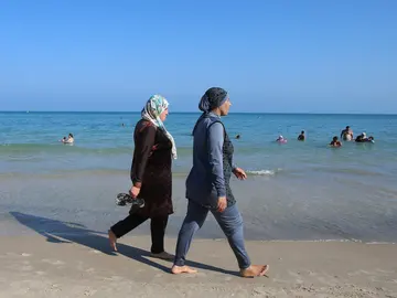 Dos mujeres vestidas con burkinis en una playa Dos mujeres vestidas con burkinis en una playa