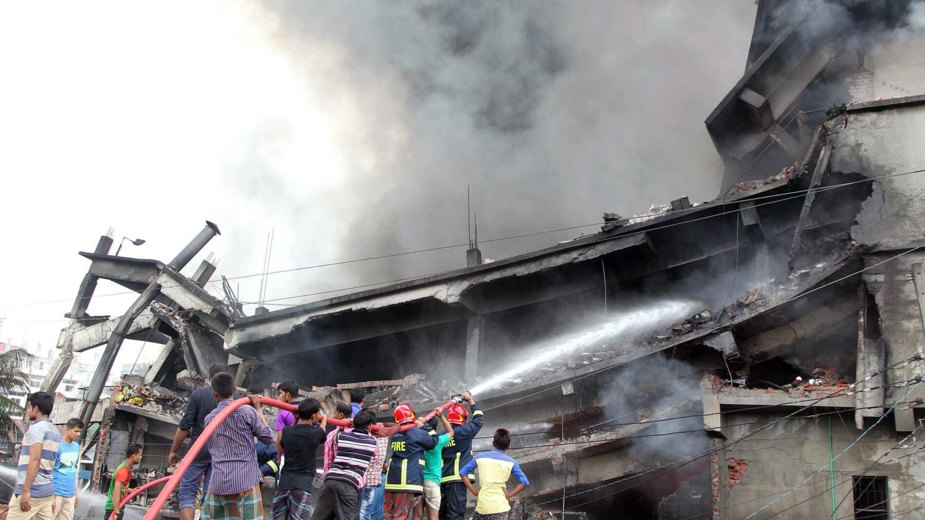 Los bomberos tratan de sofocar las llamas en la fabrica Bangladesh