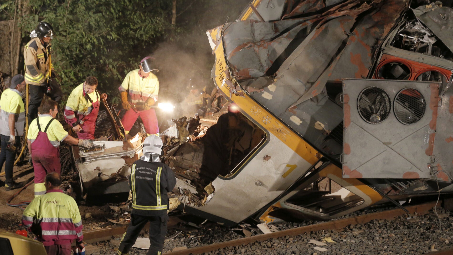 Los bomberos junto a la cabina del tren
