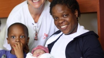 La madre de origen nigeriano,posa junto al recién nacido Newman Otas y uno de sus hermanos