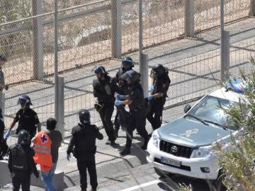 Varios agentes trasladan a un inmigrante en Ceuta