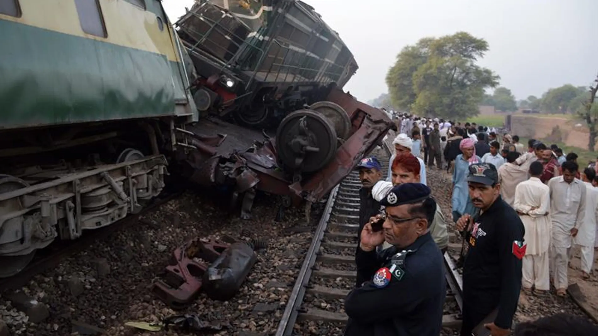 Personal de rescate y civiles observan el lugar de un accidente un tren de pasajeros Personal de rescate y civiles observan el lugar de un accidente un tren de pasajeros