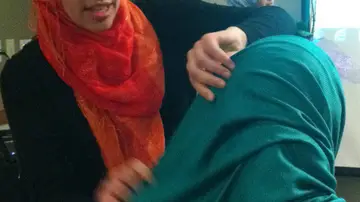 Una mujer coloca un hiyab a otra Una mujer coloca un hiyab a otra