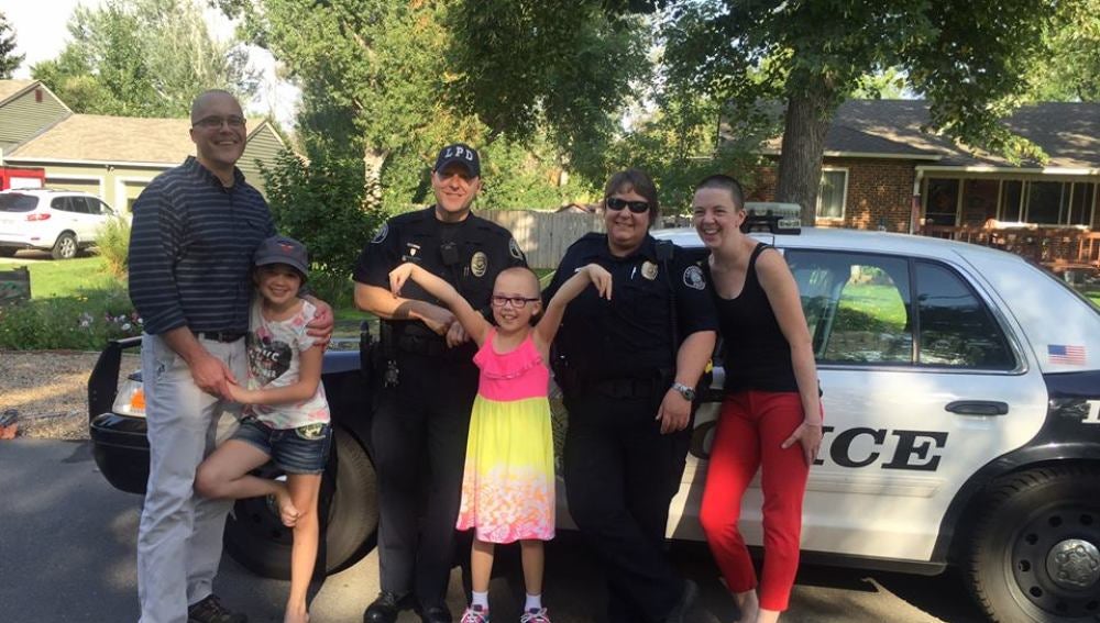 La niña junto a su familia y los dos agentes de policía