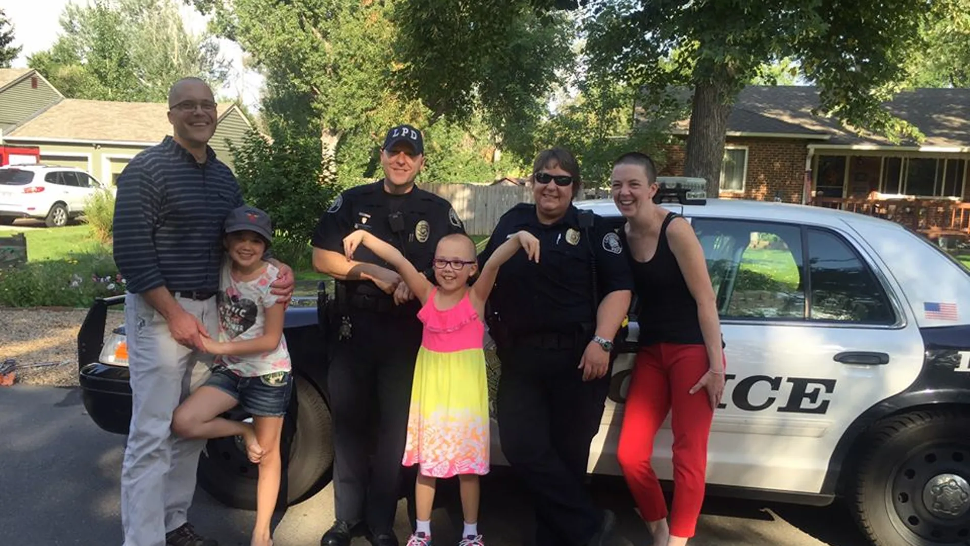 La niña junto a su familia y los dos agentes de policía La niña junto a su familia y los dos agentes de policía