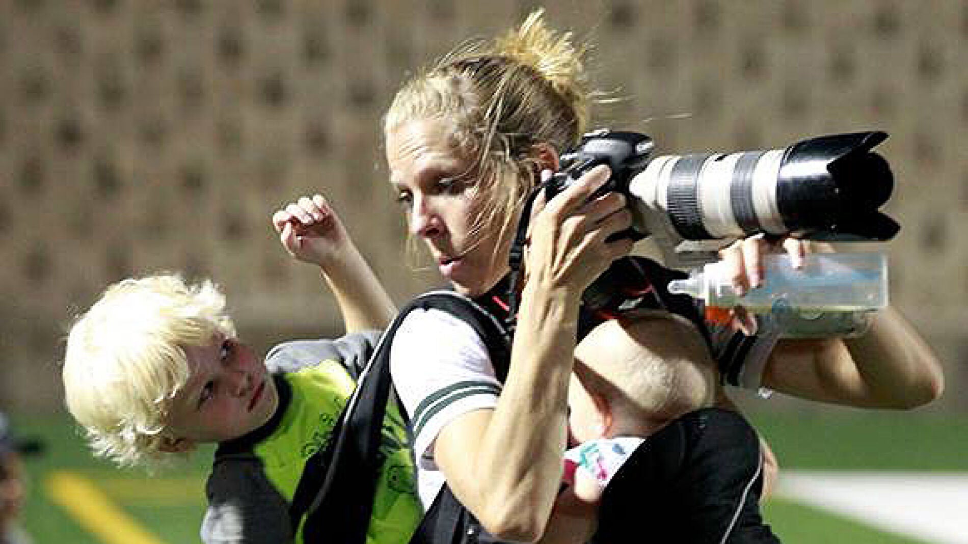 La fot&oacute;grafa trabaja mientras carga con sus dos peque&ntilde;os.