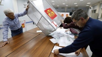 Miembros de las mesas electorales vuelcan las urnas para hacer el recuento de votos en las elecciones legislativas rusas en un colegio de Moscú