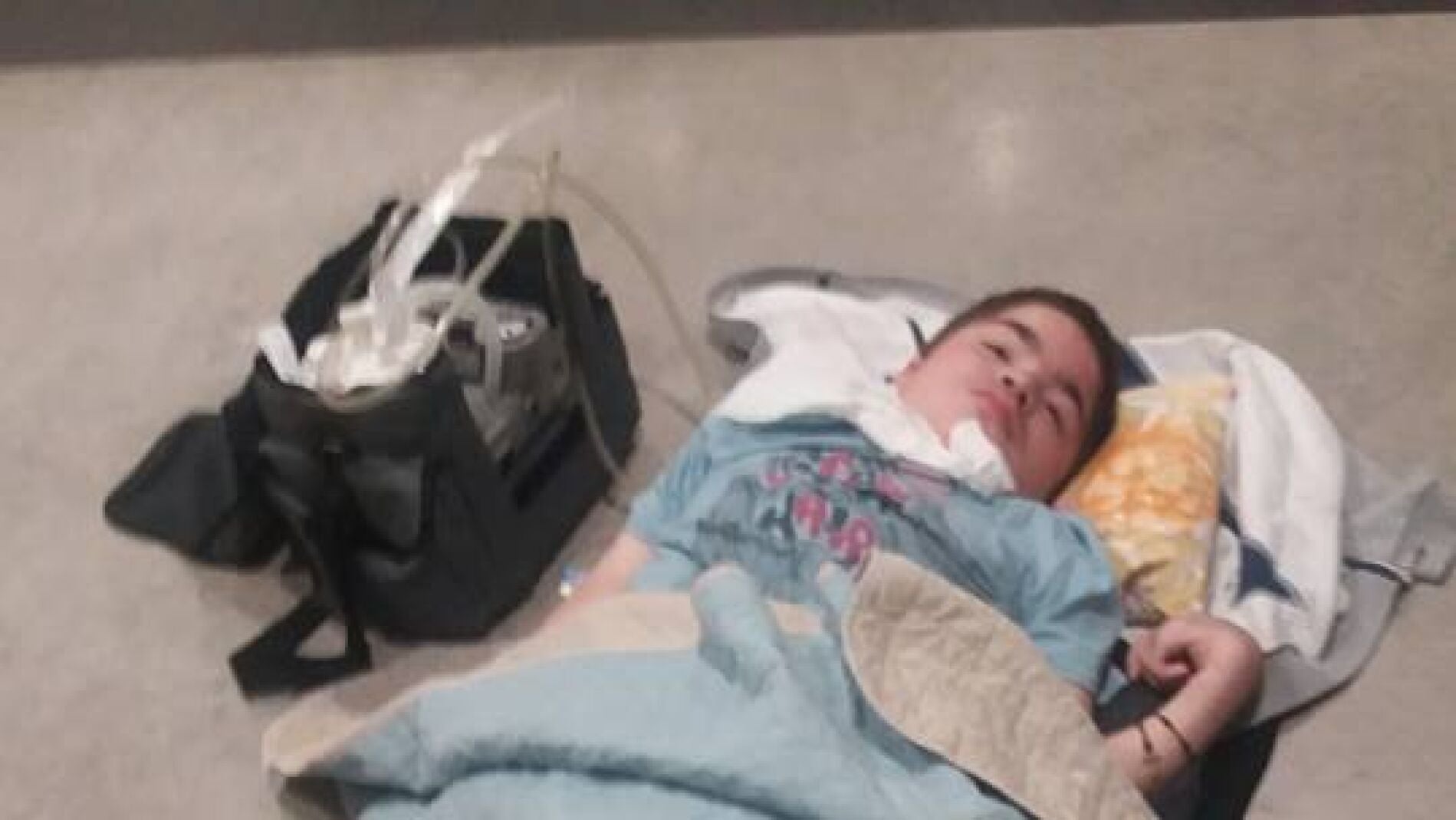 Napu, un ni&ntilde;o en estado terminal tirado en el suelo en un aeropuerto