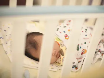 Un bebé duerme en una cuna Un bebé duerme en una cuna