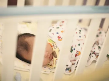 Un bebé en una cuna Un bebé en una cuna