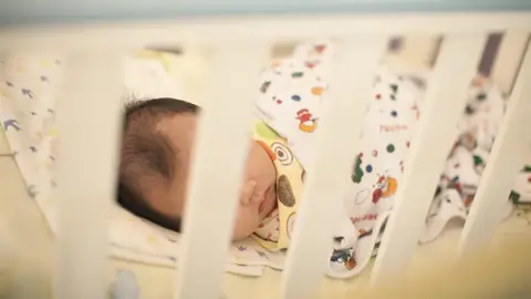 Un bebé en una cuna Un bebé en una cuna