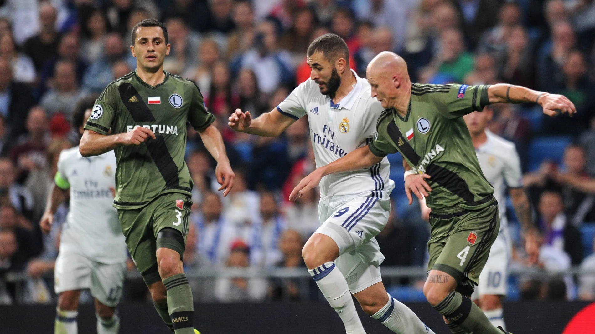 Benzema conduce el balón ante dos jugadores del Legia