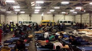 Decenas de personas evacuadas por los terremotos, pasan la noche en un hangar de autobuses convertido en refugio temporal en Italia