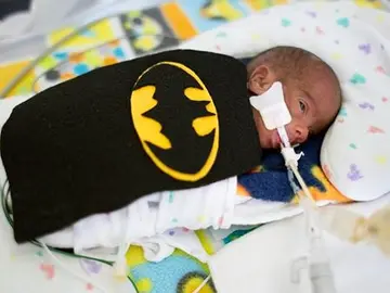Uno de los bebés con un disfraz de Batman Uno de los bebés con un disfraz de Batman