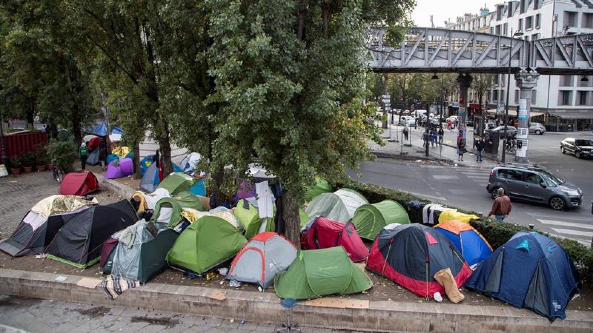 Vista general de varios inmigrantes junto a sus tiendas de campa&ntilde;a en un campamento cerca de las estaciones de metro de Jaur&egrave;s y Stalingrad, en Par&iacute;s