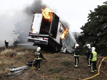 Varios bomberos intentan sofocar el incendio que se originó en un camión frigorífico