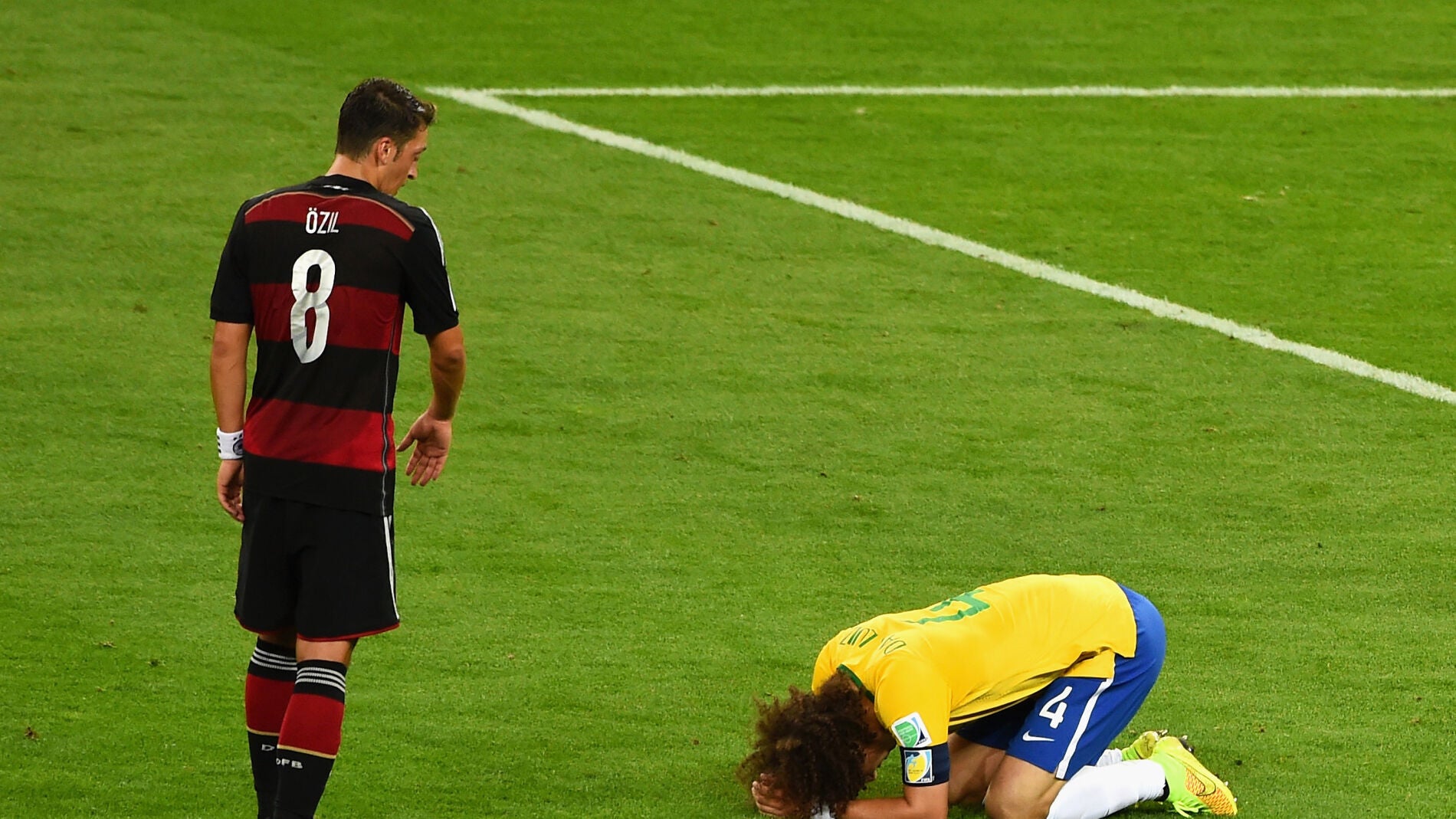 Mesut &Ouml;zil, acerc&aacute;ndose a un desconsolado David Luiz tras la eliminaci&oacute;n de Brasil en el Mundial 2014