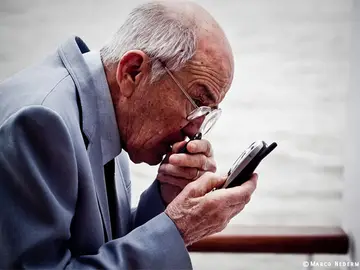 Abuelo mirando un smartphone Abuelo mirando un smartphone