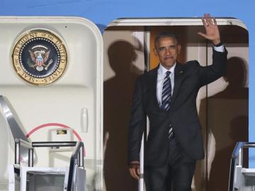 Obama saluda tras aterrizar en el aeropuerto de Tegel, en Berlín