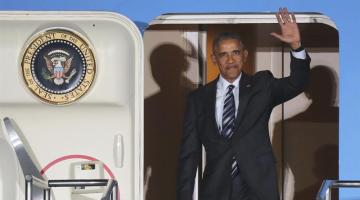 Obama saluda tras aterrizar en el aeropuerto de Tegel, en Berlín